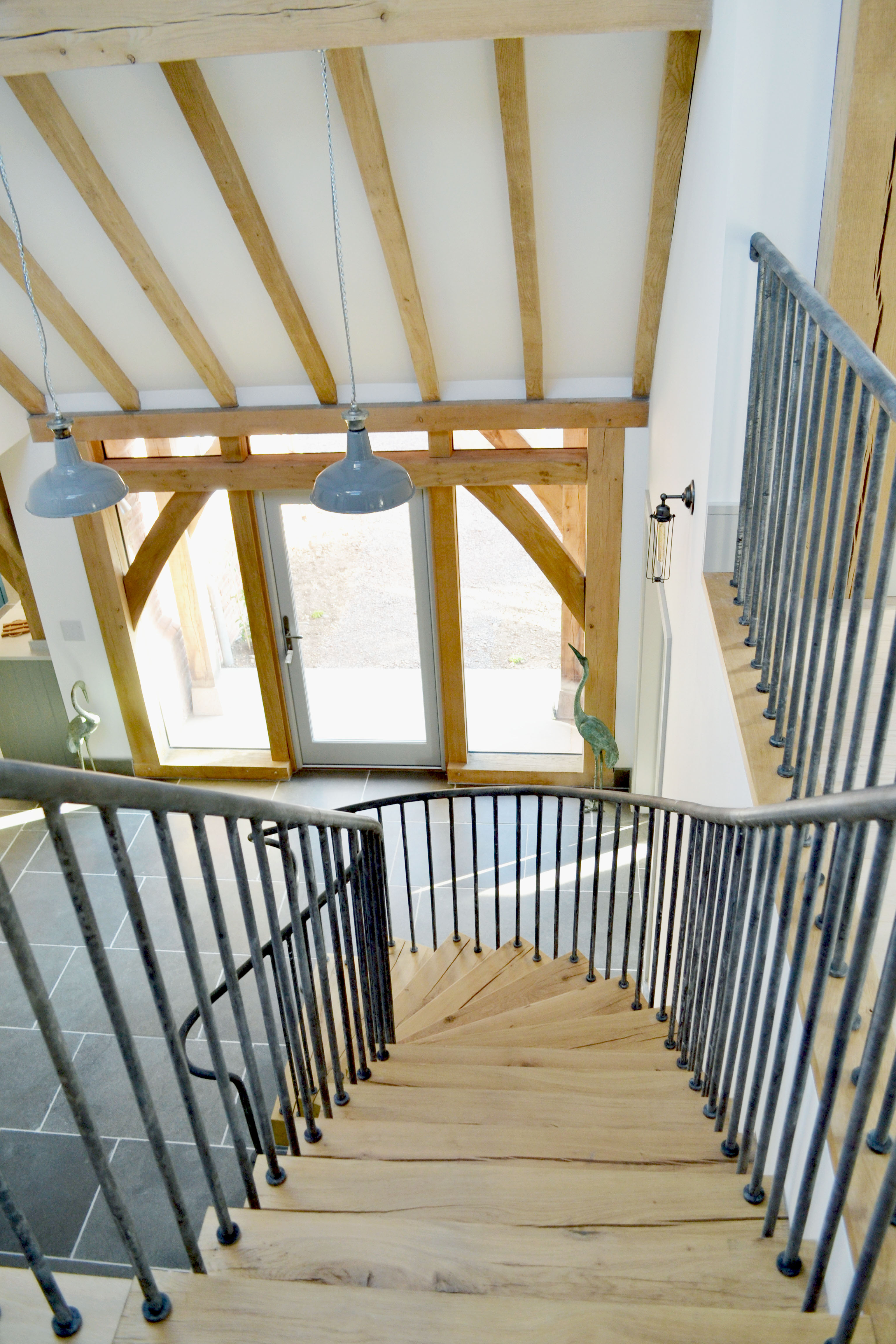 Curved oak staircase under exposed oak beams